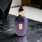 Luxuriöser lila Parfumflakon Purple Accento mit goldfarbenem Verschluss auf Marmortisch
