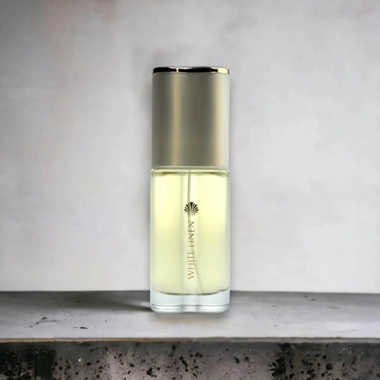 Eleganter Parfumflakon mit goldenem Deckel und weißer Aufschrift WHITE LINEN auf neutralem Hintergrund.
