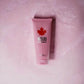 DSQUARED2 Wood Charming Bath & Shower Gel in rosa Tube auf rosa Marmorhintergrund