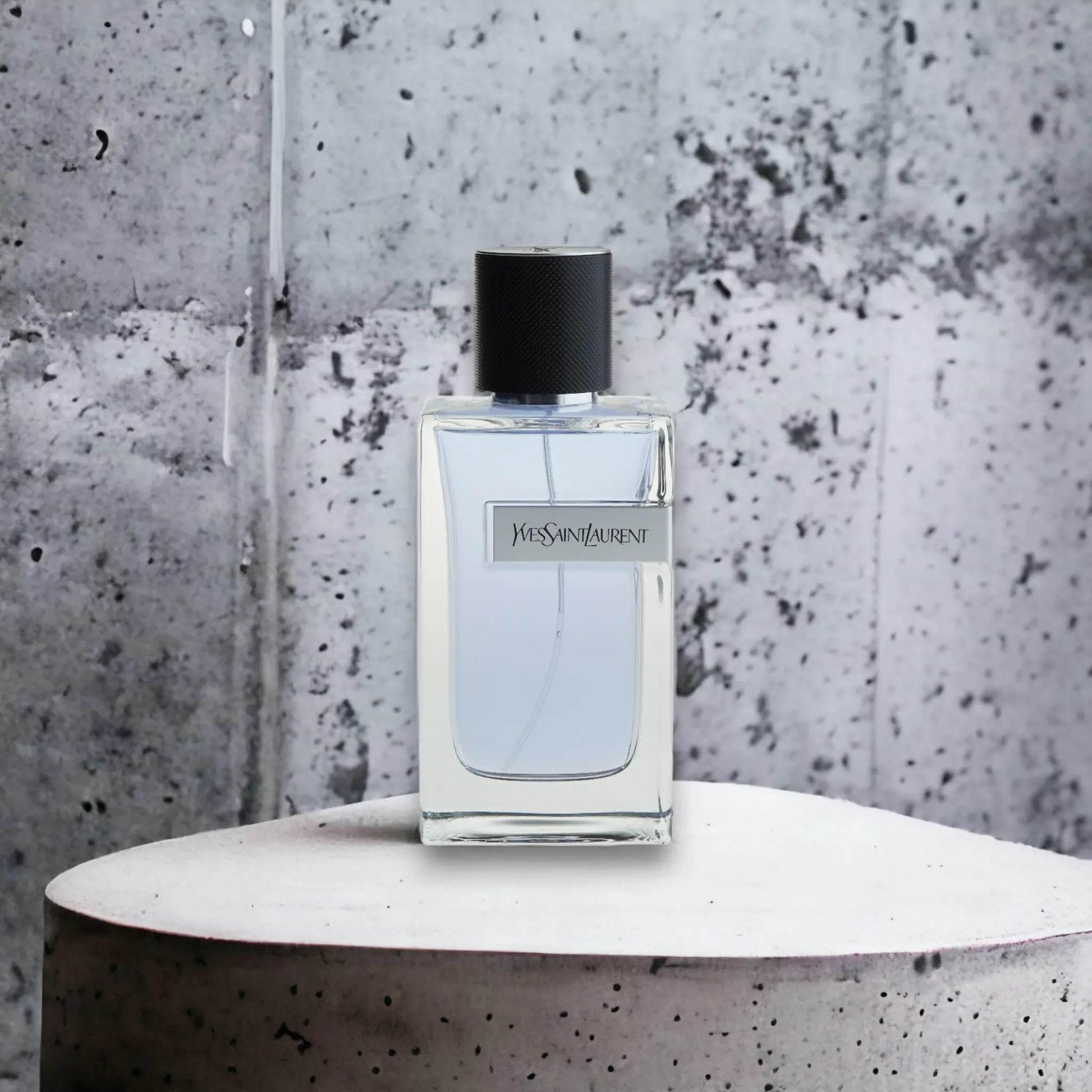 Yves Saint Laurent Eau de Toilette Flakon vor Betonhintergrund, luxuriöses Herrenparfum