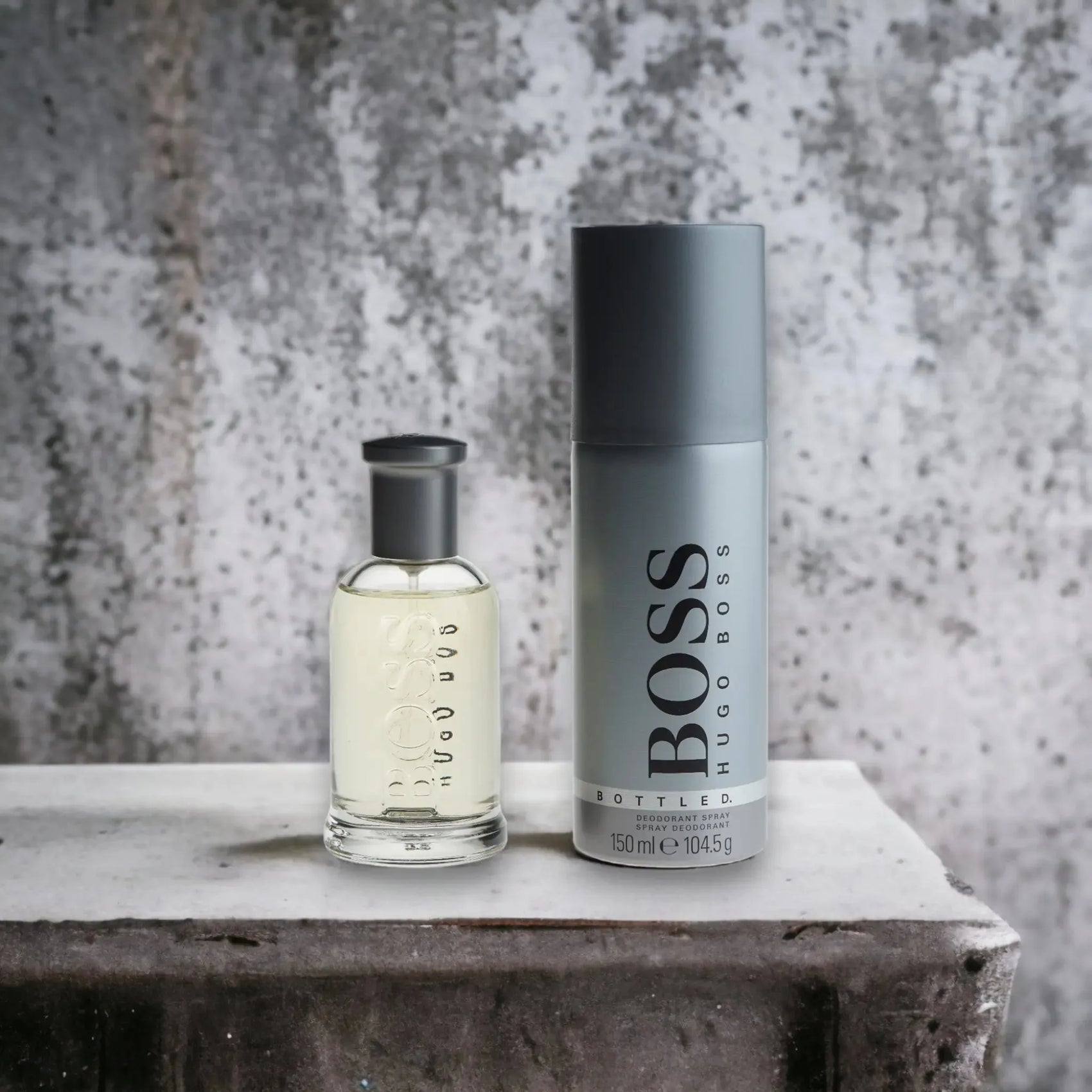 Duftset mit Hugo Boss Eau de Toilette und Deo Spray auf Betonhintergrund