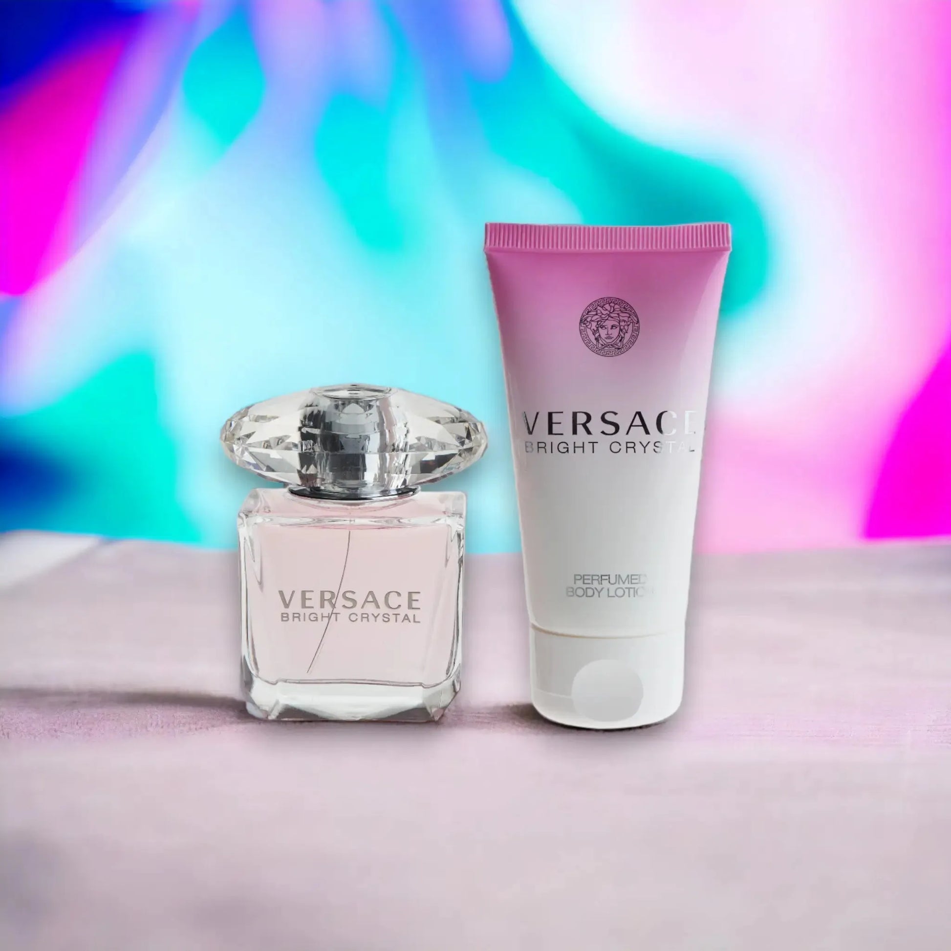 Versace Bright Crystal Parfumflakon und Bodylotion auf pastellfarbenem Hintergrund