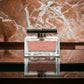 Luxuriöses Parfumflakon mit rosafarbenem Duft, goldener Deckel, Marmortisch, elegant
