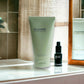 Jil Sander Evergreen Duschgel Tube und schwarzes Kosmetikfläschchen im Badezimmer am Waschbecken