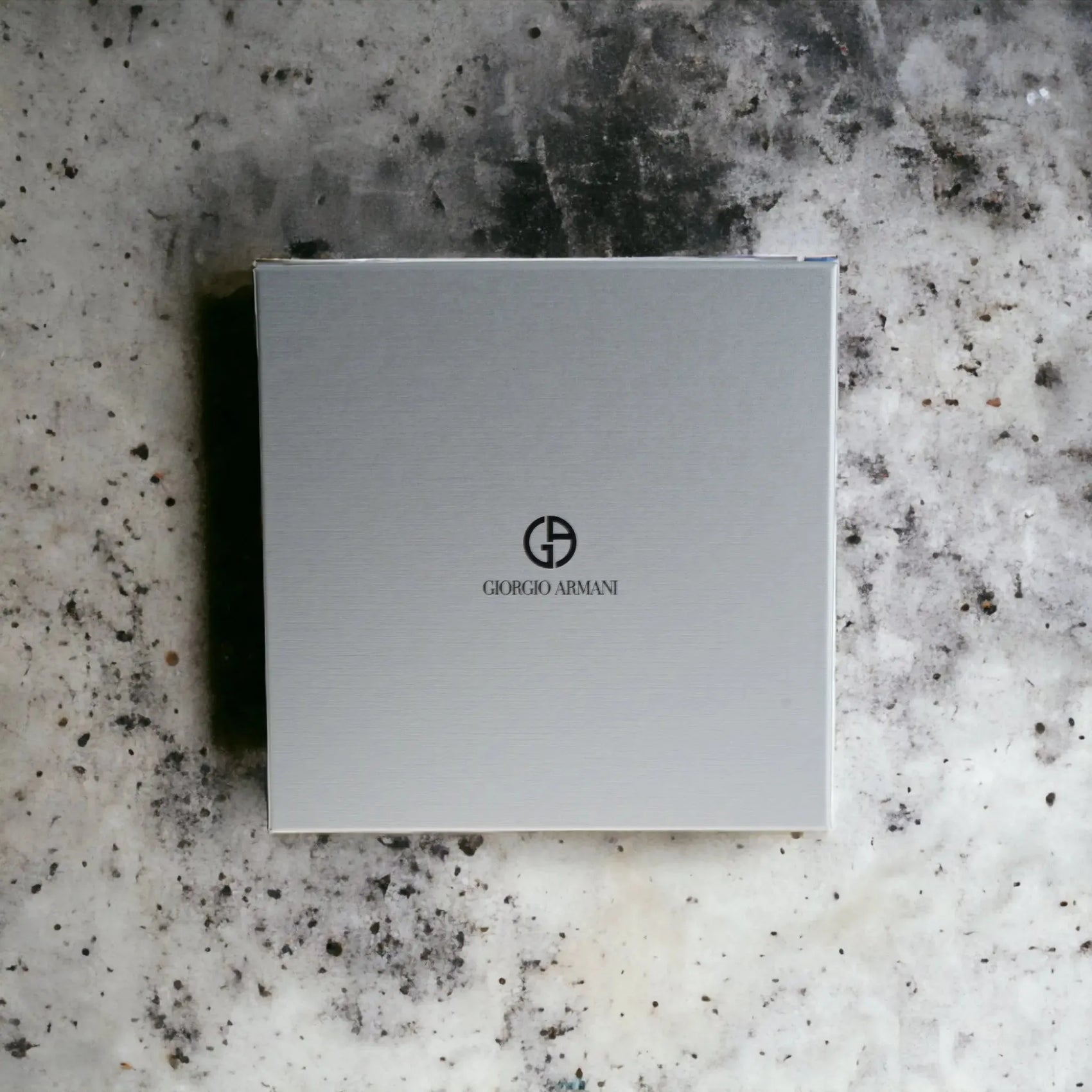 Giorgio Armani Geschenkbox auf marmoriertem Untergrund, schlichtes Parfum-Set-Design.