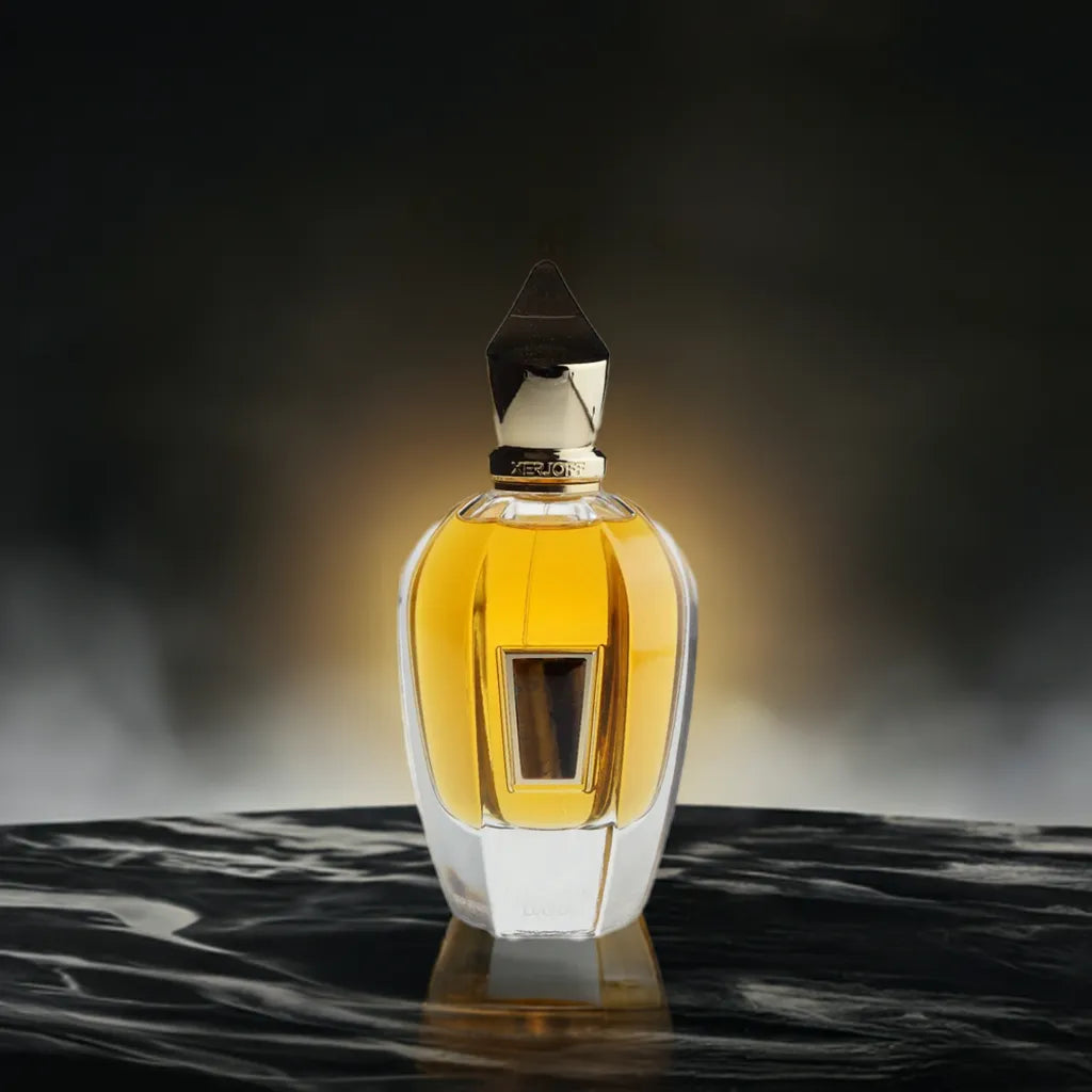 Luxuriöser Parfumflakon mit goldener Kappe auf dunklem, stilvollem Hintergrund.