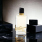 Luxuriöses Eau de Parfum in elegantem Flakon mit goldenen Details auf schwarzem Marmortisch