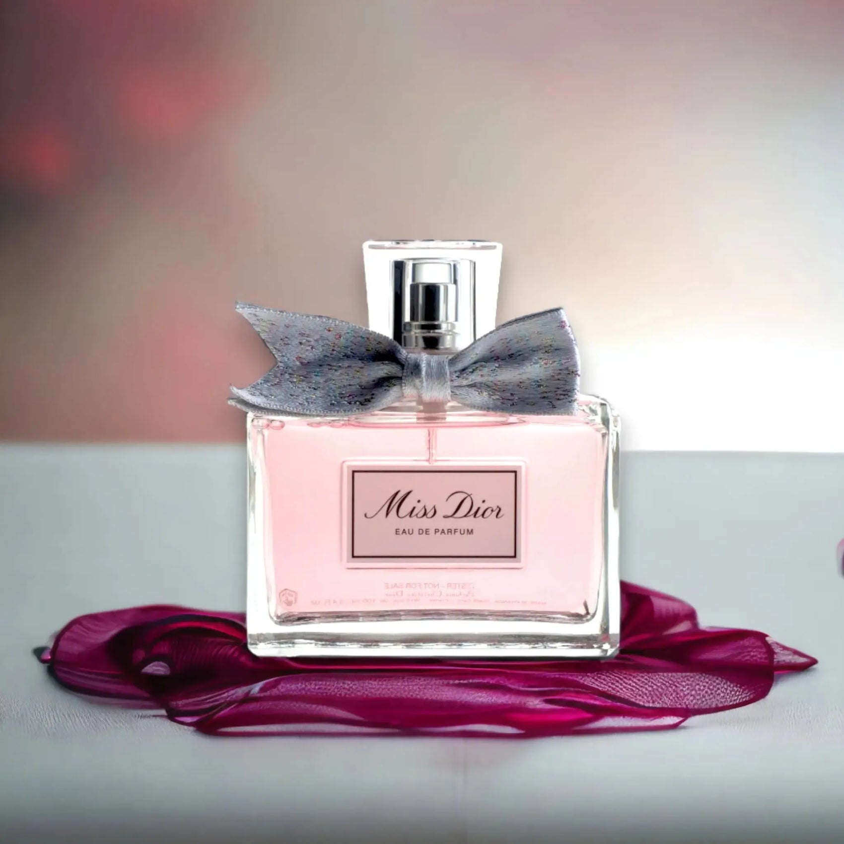 Miss Dior Eau de Parfum Flakon mit Schleife, rosa Duft, luxuriös, auf Stoffdekor drapiert