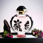Flakon Olympea Flora Intense Parfum mit floraler Verzierung, umgeben von Blumen