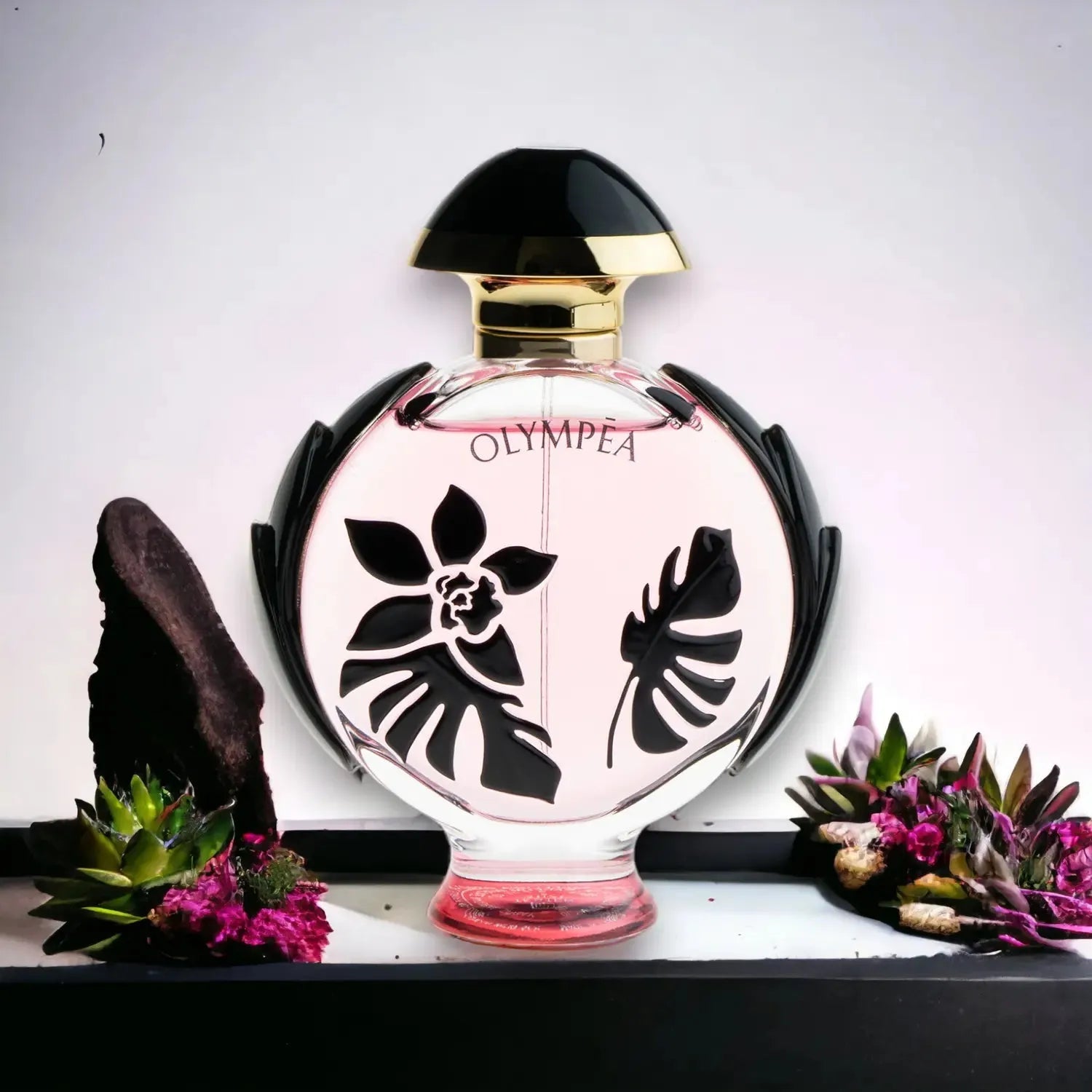 Flakon Olympea Flora Intense Parfum mit floraler Verzierung, umgeben von Blumen