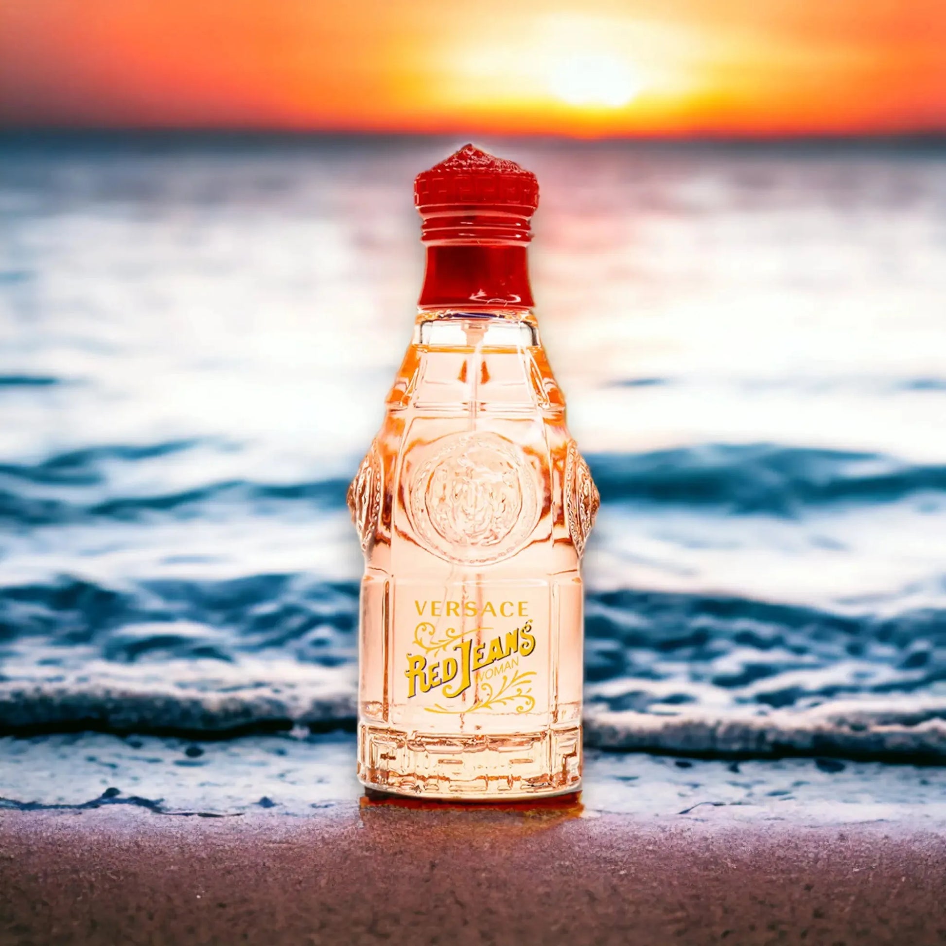 Versace Red Jeans Eau de Toilette Flakon am Strand bei Sonnenuntergang, Meer im Hintergrund