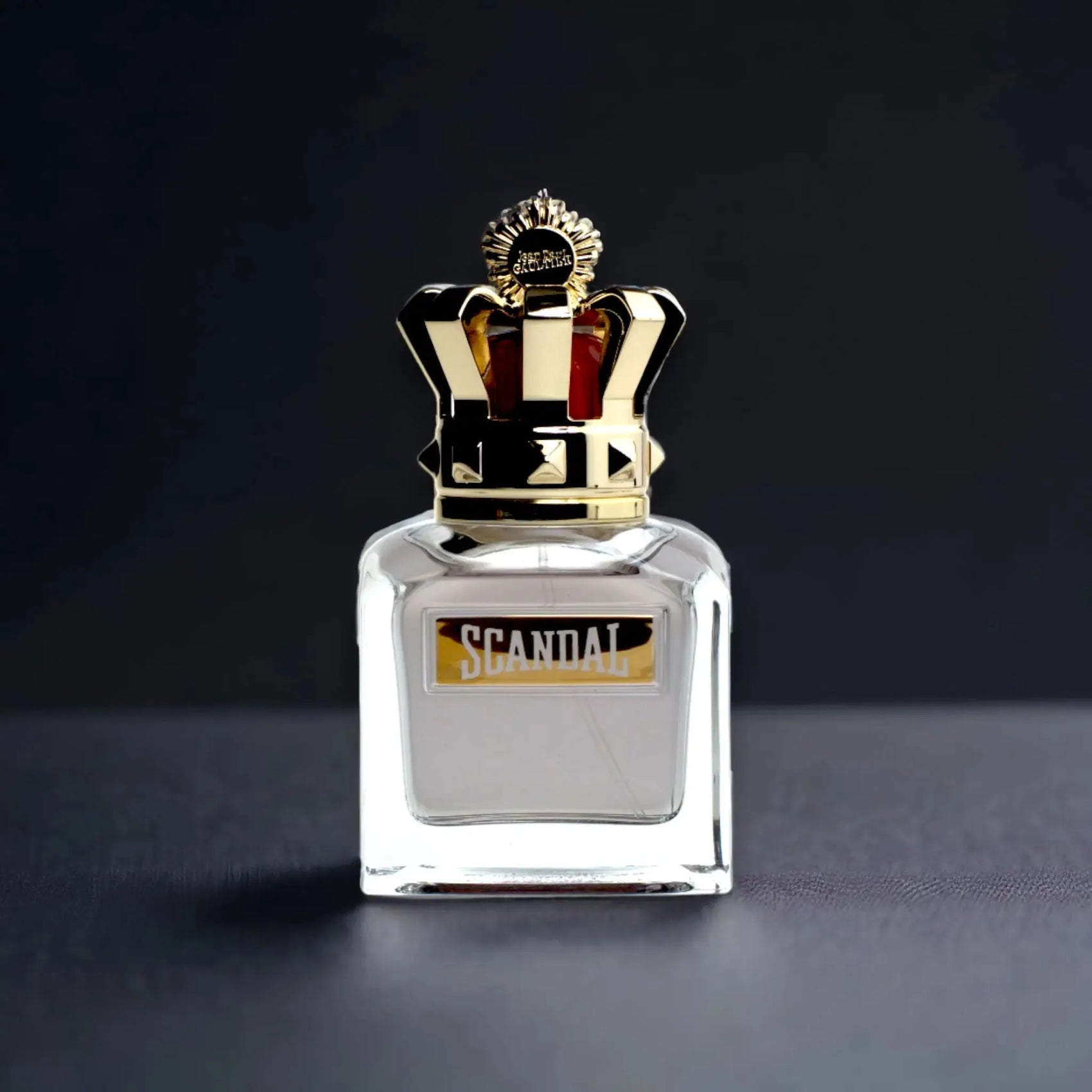 Luxuriöser Scandal Eau de Toilette Flakon mit goldener Krone auf dunklem Hintergrund