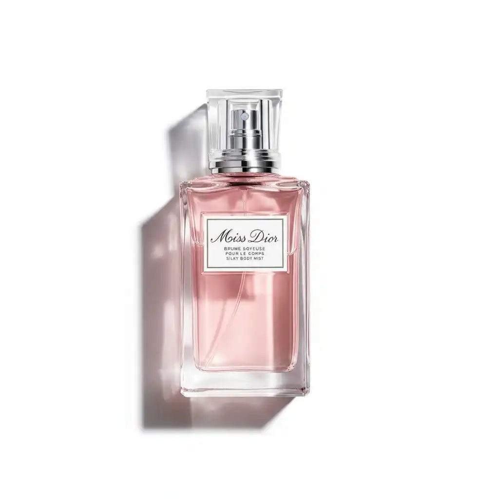 Ein gläserner Flakon mit Miss Dior Body Mist in zartem Rosa auf weißem Hintergrund.