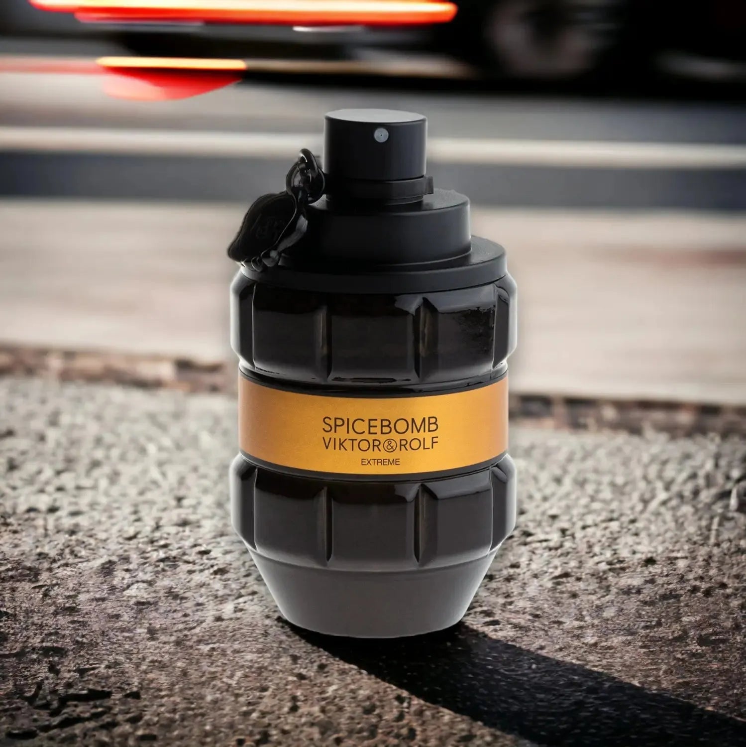 Schwarzer Parfumflakon Spicebomb Extreme auf Asphalt, Nahaufnahme mit goldfarbenem Etikett