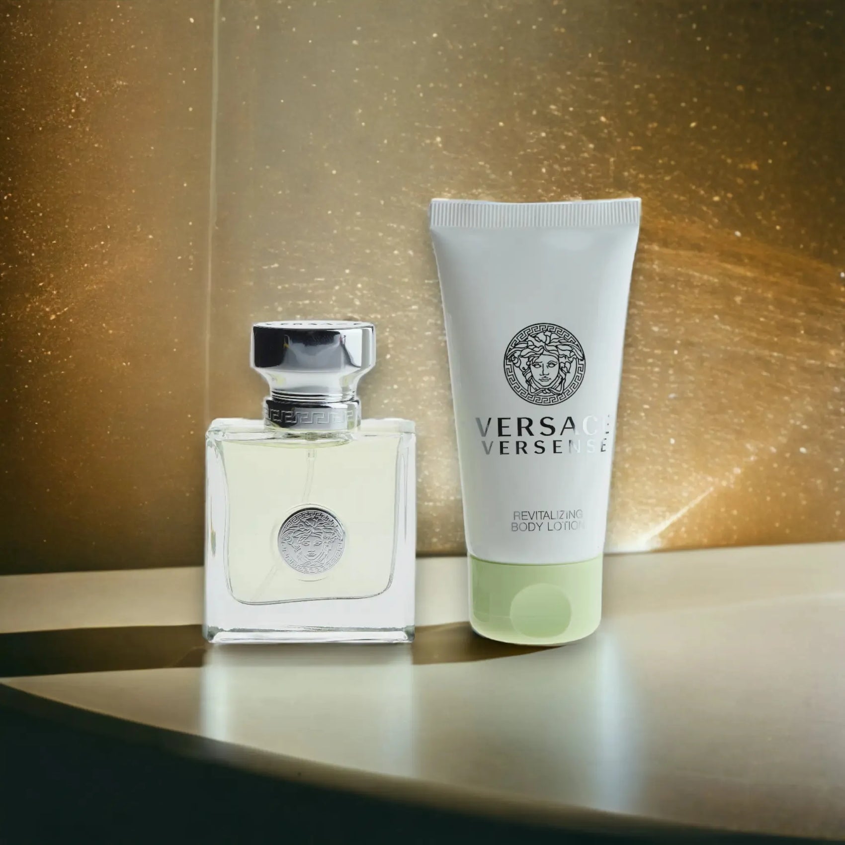 Versace Versense Duftset mit Eau de Toilette und Body Lotion vor gold schimmerndem Hintergrund